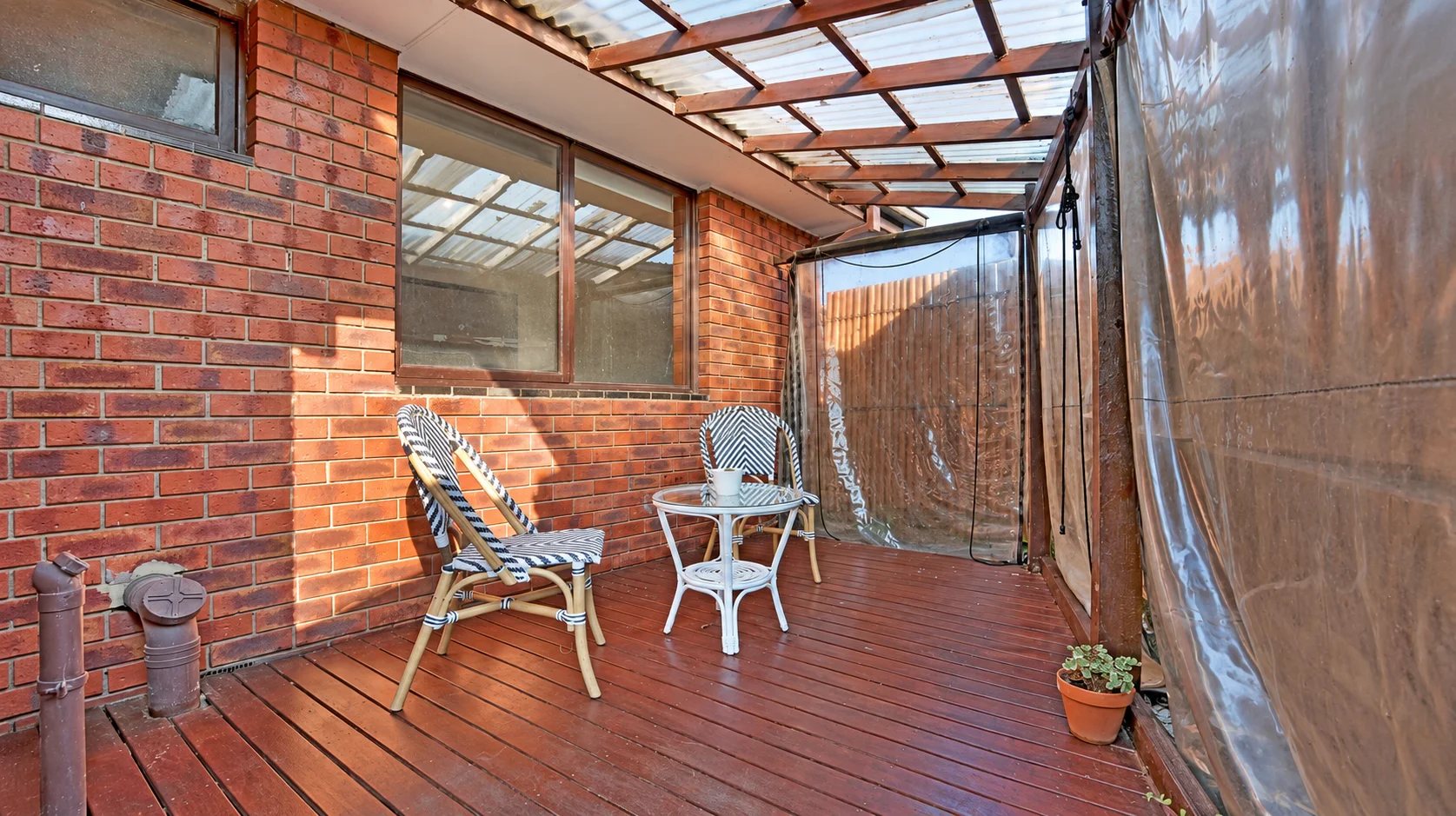 Patio at our Lalor home renovation before: old roofing and plastic screens over a weathered deck